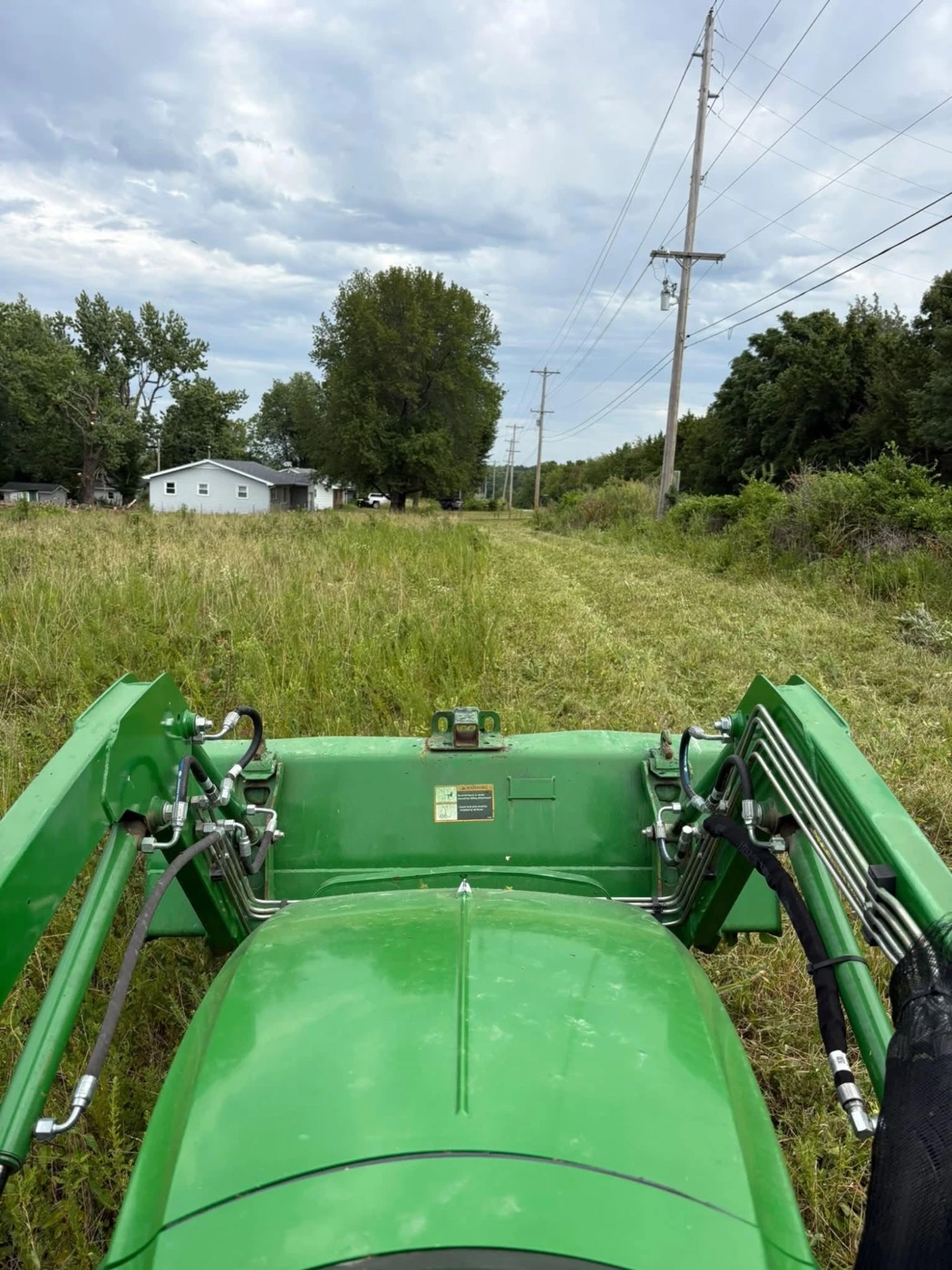 View from the seat of Krislyn's tractor, a freshly brush-hogged strip cut through tall grass
